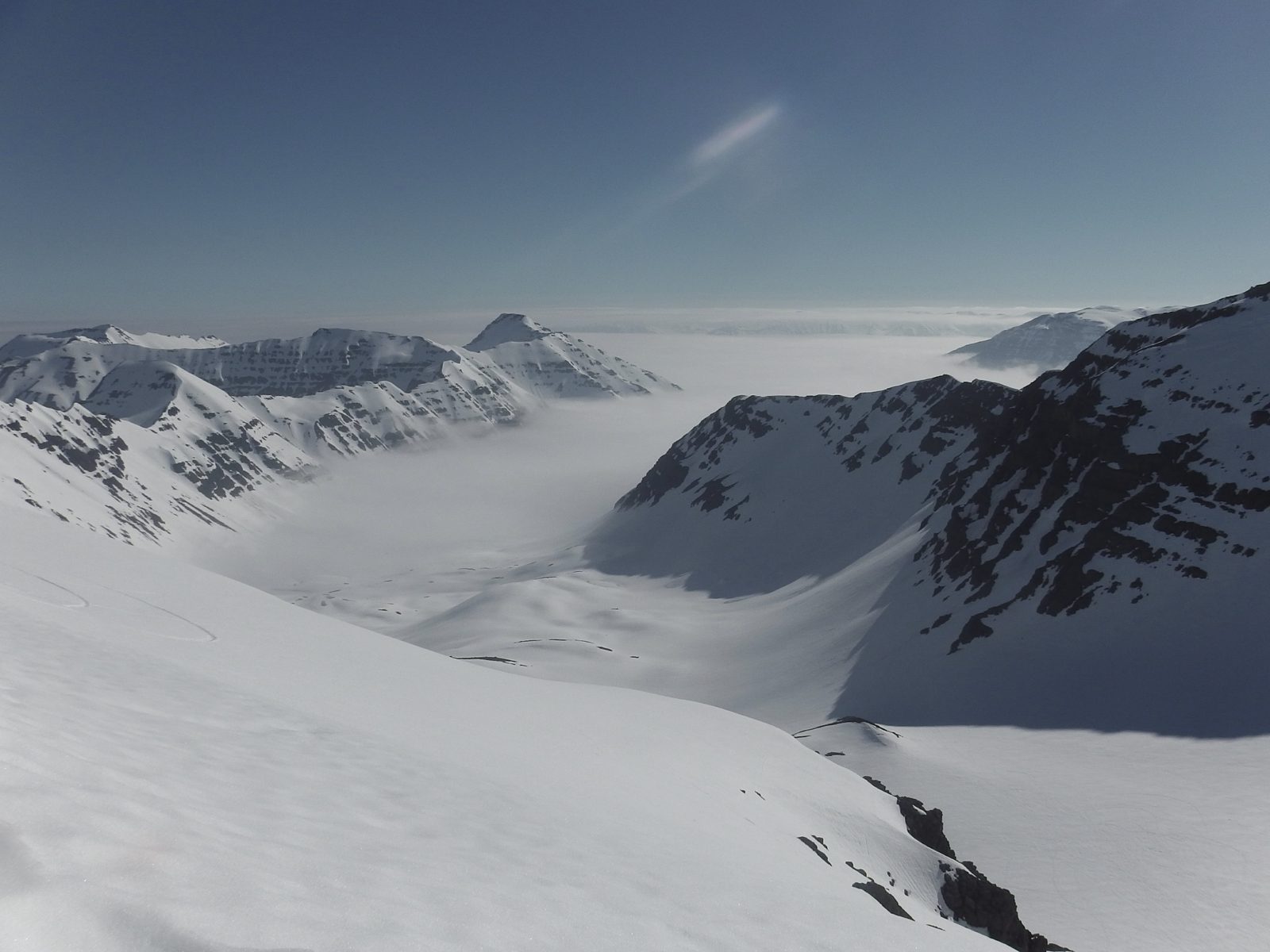 Snowy peaks of the Troll Peninsula rising above a sea of cloud