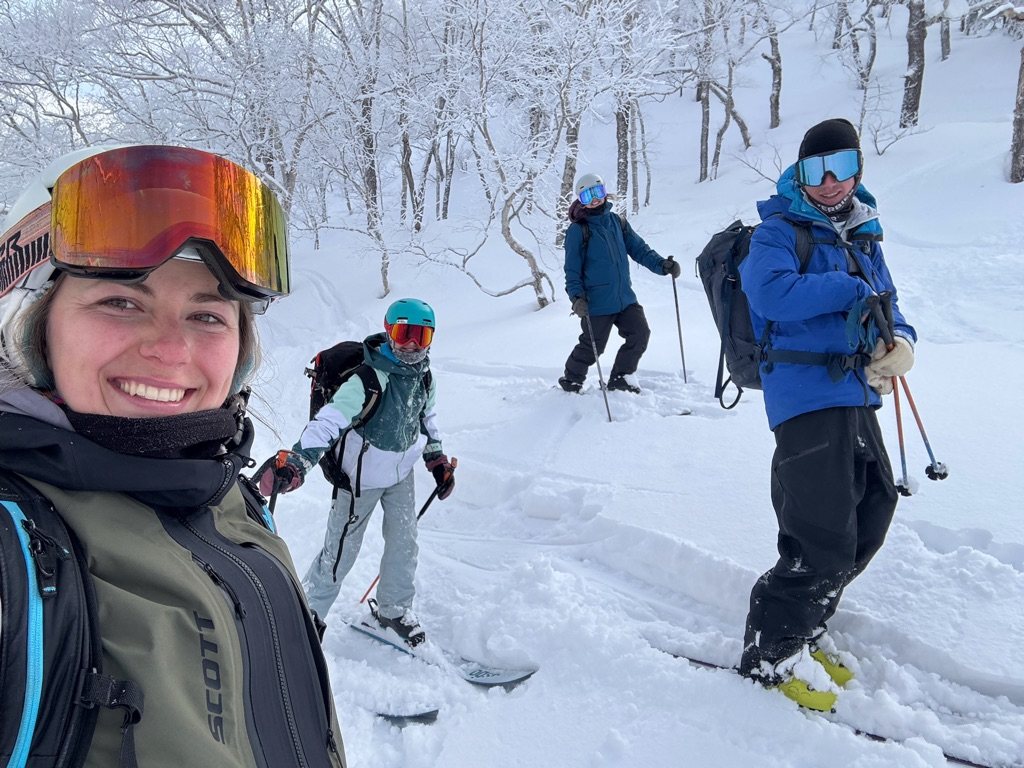 A group in deep powder among snow-covered birch trees in Hokkaido